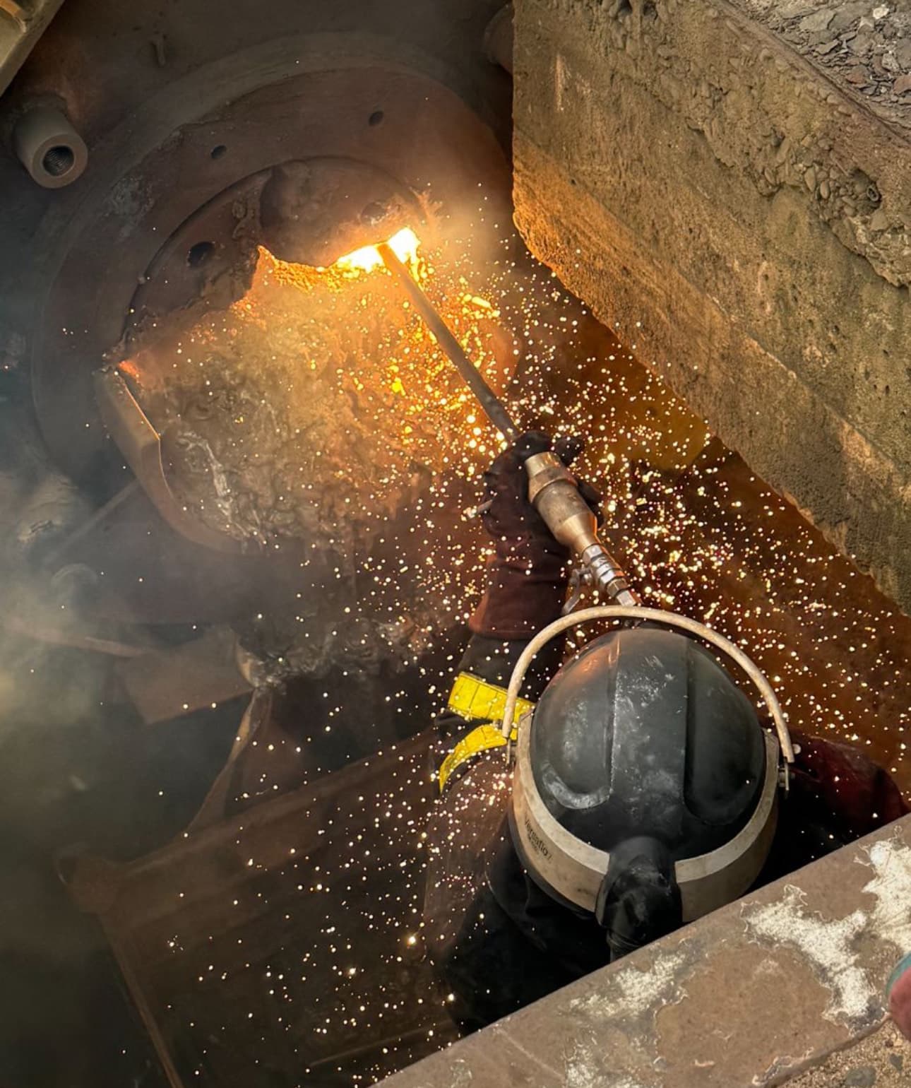 Industriële reparatie met vonkenregen tijdens slijpwerk in close-up